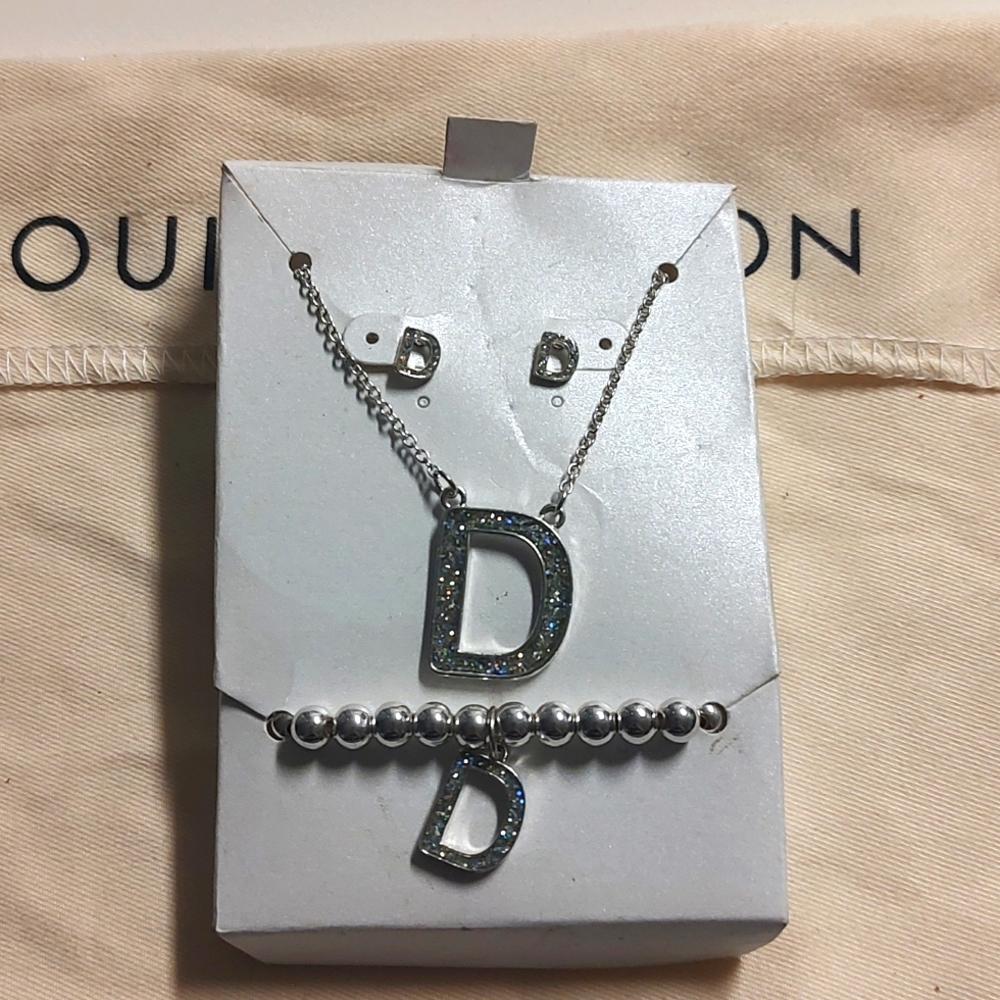 NWT Set of D initial in silver tone with rainbow jewel around it.